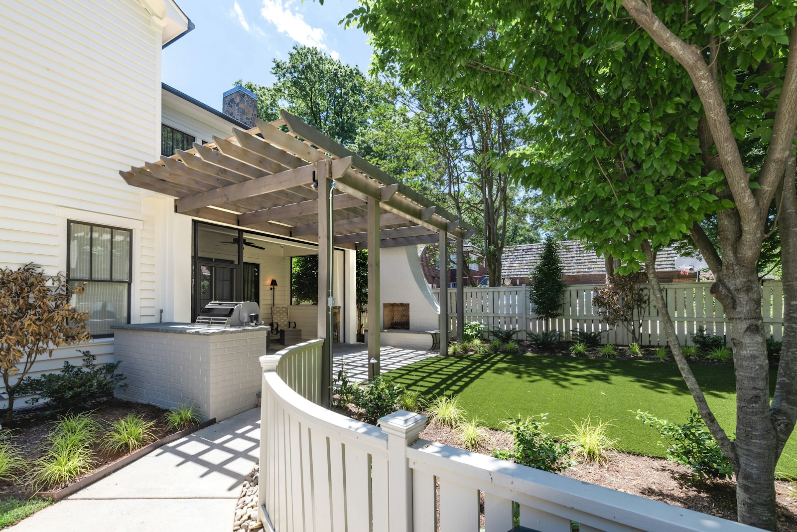 Sfeerbeeld: een tuin met een houten pergola en terras